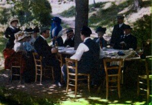 Люмьеры: семейный обед. Луи Люмьер сидит у дерева, Огюст, в фуражке, стоит возле стола. Первое цветное фото. Братья Люмьер. 1910 г.